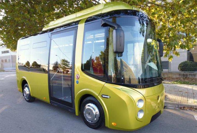 Autobús de color verde limón estacionado, con puertas abiertas y ventanas oscuras.