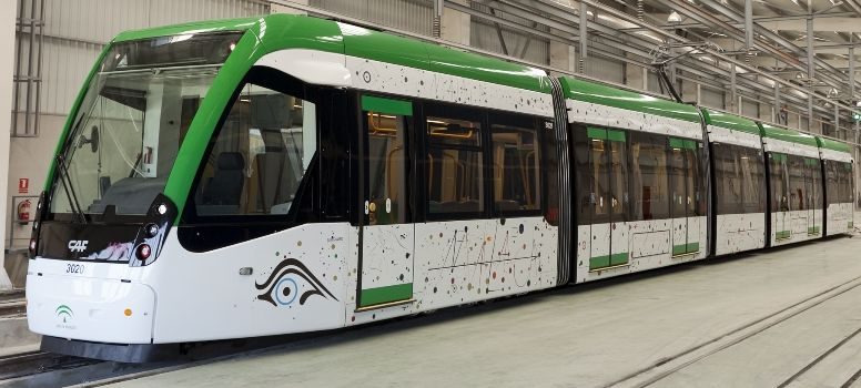 Tranvía CAF Urbos 3 Metro de Málaga Tren ligero moderno de color verde y blanco en un ambiente industrial.