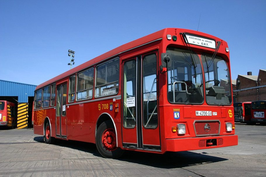 Autobús Pegaso 6038 EMT Madrid Autobús urbano rojo estacionado, con un cielo azul y edificios industriales al fondo.