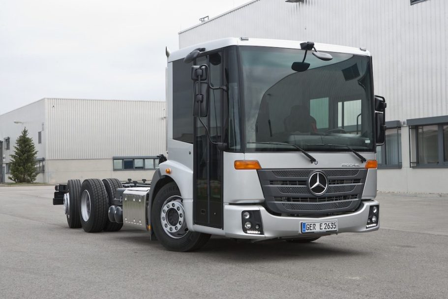 Camión Mercedes Benz Econic Camión Mercedes-Benz de cabina grande, color plateado, en un área industrial.