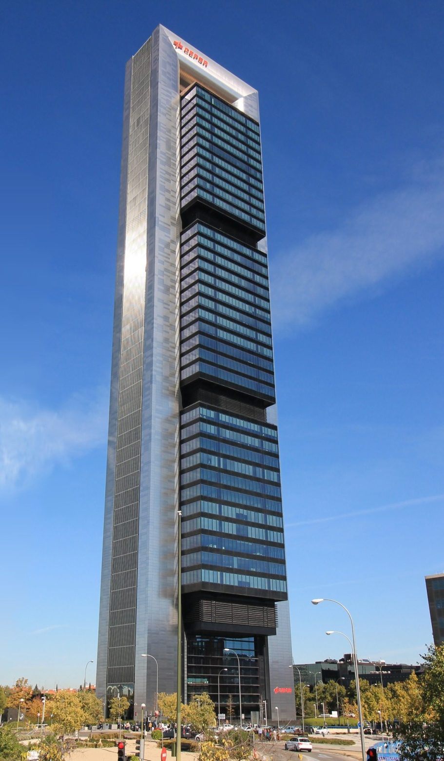 Edificio en Madrid Torre Fóster Repsol Rascacielos moderno con fachada de vidrio y estructuras horizontales en un entorno urbano.